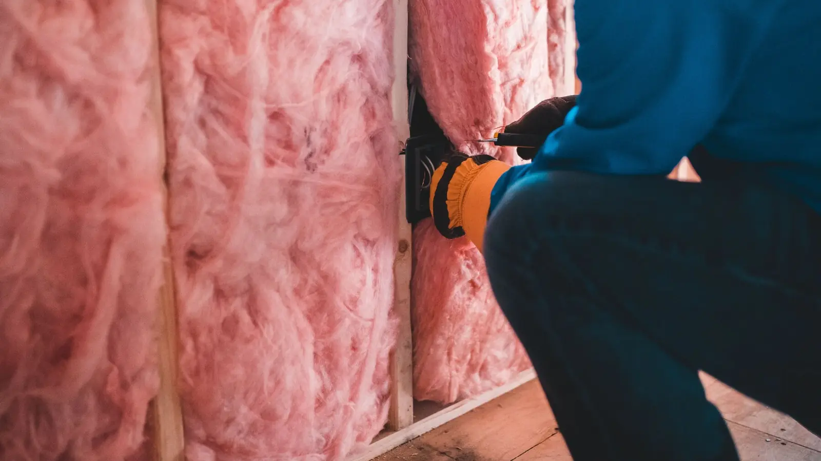 Wełna mineralna wciskana między elementy konstrukcji ściany